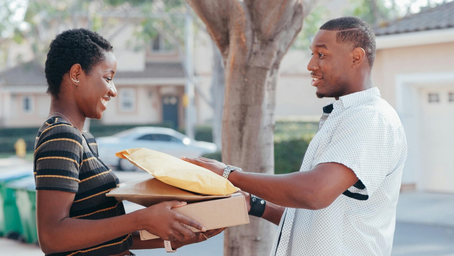 A man handing another man pizza box